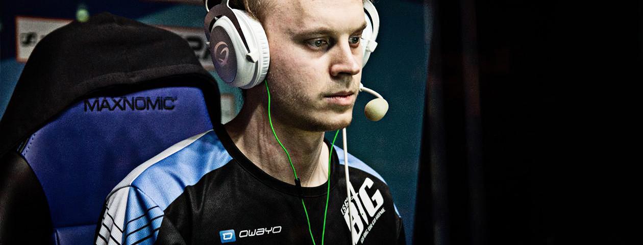 Ein Spieler mit Kopfhörern und einem Trikot von owayo sitzt vor einem Gaming-Stuhl.