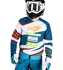 A motorcyclist wearing a helmet and a striped jersey with various logos on it.