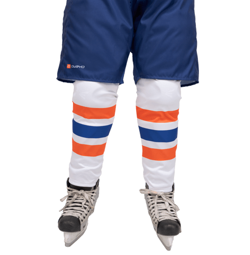 Un jugador de hockey lleva pantalones cortos azules con el logo 'owayo', medias blancas con franjas naranjas y azules, y patines de hockey.