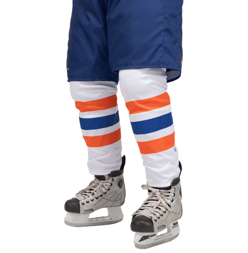 Un jugador de hockey sobre hielo con pantalones azules y calcetines blancos con rayas naranjas y azules, combinados con patines de hockey.