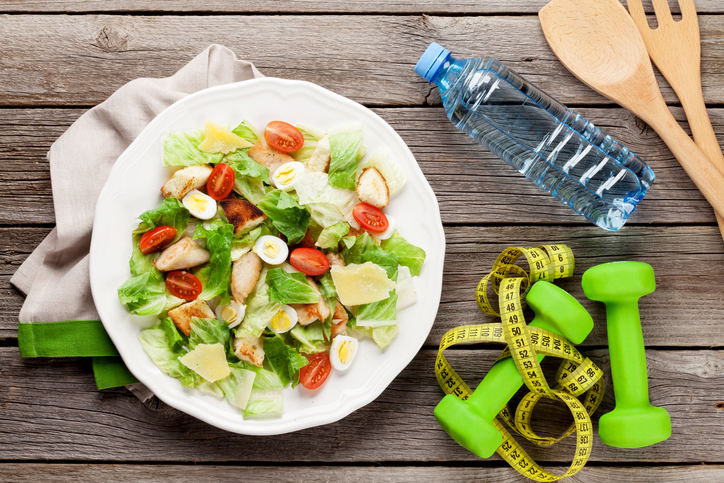 Salat mit Hanteln, Maßband und Wasser