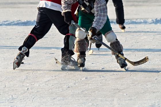 Eishockey-Spieler auf einem zugefrorenen Teich.