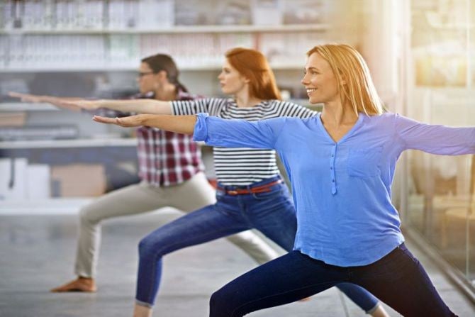 Mitarbeiterinnen machen Yoga im Rahmen von Firmenfitness