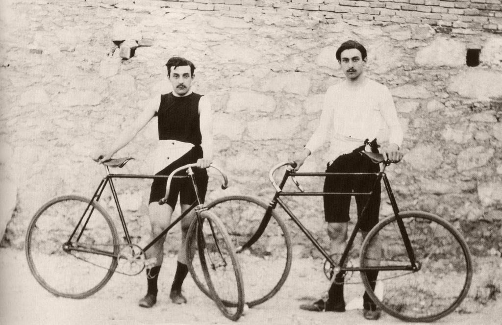A black and white photo of cyclists with bicycles and tight-fitting sportswear