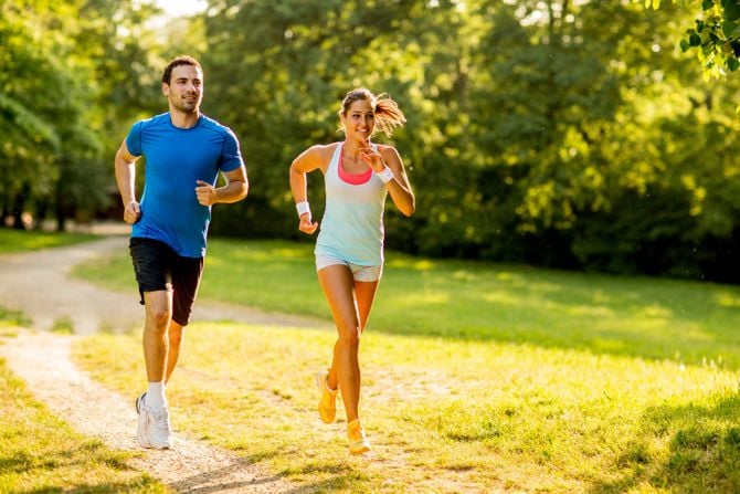 Ein Mann und eine Frau joggen im Sommer bei Hitze.