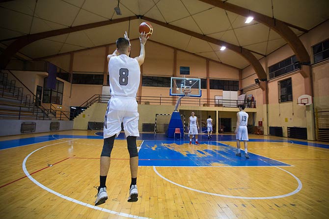 Basketball player performing a basketball jump shot in a gym