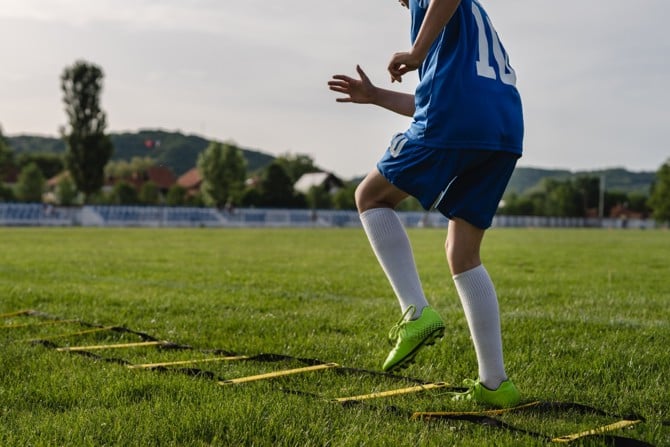 Fußballer trainiert mit Koordinationsleiter