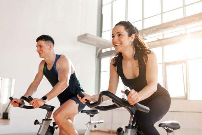 Frau und Mann trainieren auf dem Indoor-Bike