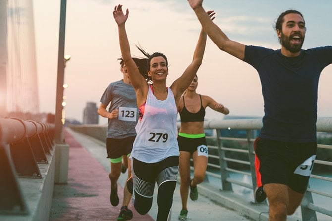 Marathon runners with raised arms