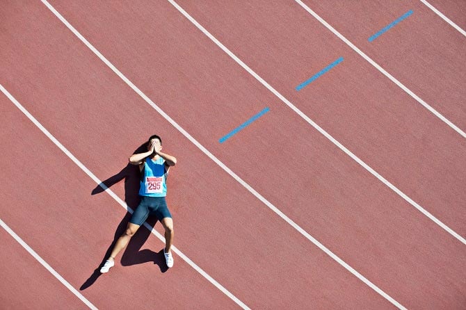 Exhausted athlete lies on the track