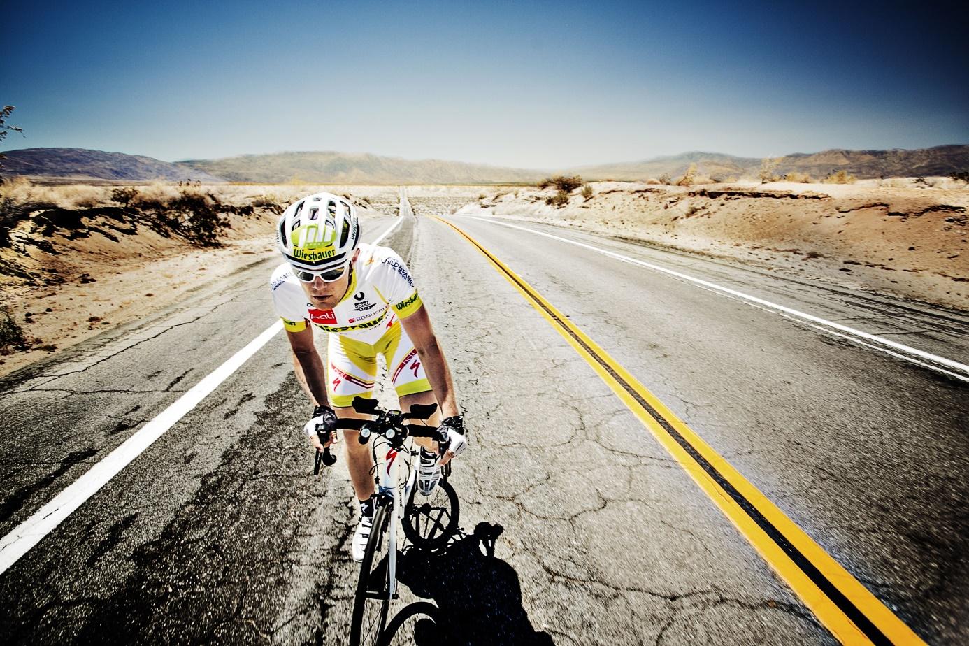 Christoph Strasser, high-level athlete, cycling on a road in the United States