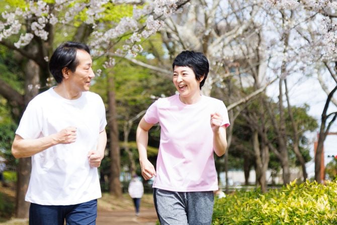 Zwei Menschen joggen langsam im Park