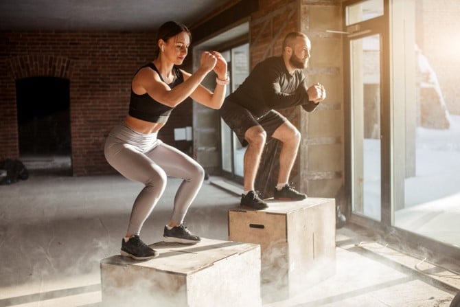 Sportler trainieren Sprungkraft mit Box Jumps