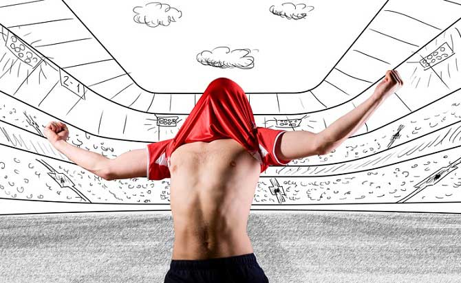 Soccer player stands in a drawn stadium and pulls his jersey over his head in jubilation 