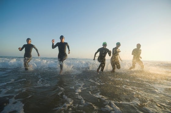 Schwimmer rennen aus dem Meer beim Triathlon