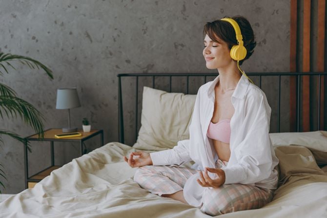 Woman does yoga in bed before sleeping