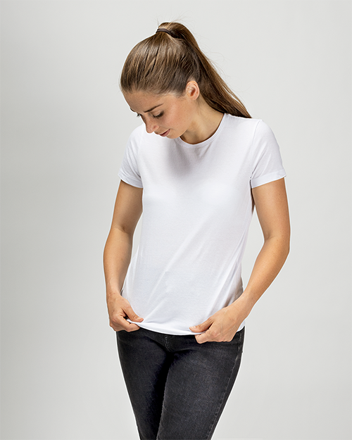 Een vrouw draagt een wit T-shirt met ronde hals en spijkerbroek. Het beeld toont het voorzijde van het T-shirt.