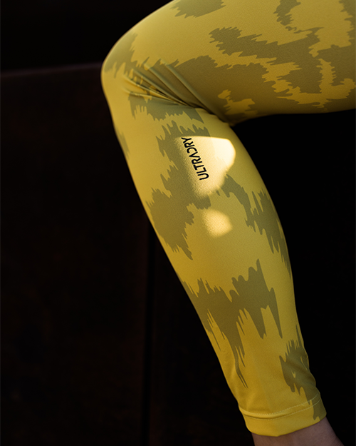 Legging jaune avec un motif abstrait et le texte 'ULTRA' au bas.