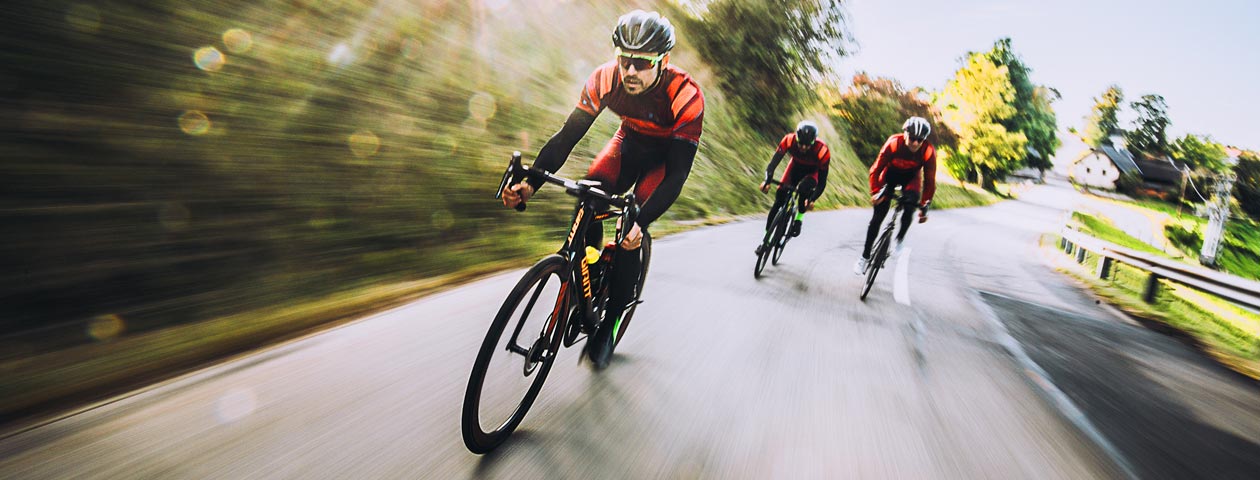 カスタムデザインのサイクルジャージとサイクルパンツを着て走行する3人のロードバイカー